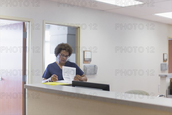 African American nurse writing in hospital