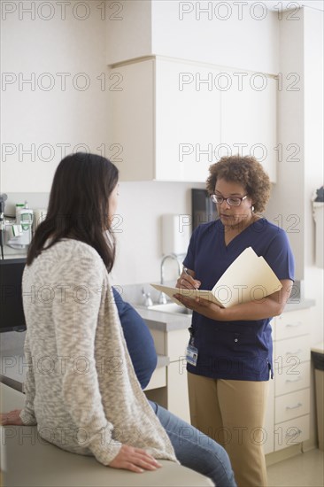 Nurse talking to pregnant patient in hospital room