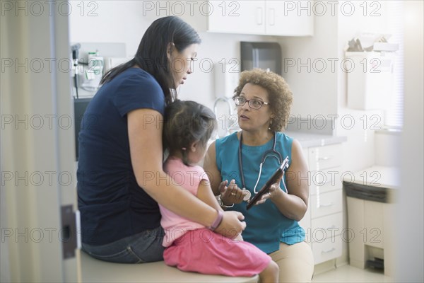 Doctor using digital tablet with patients