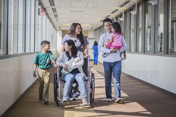 Nurse with patient and family in hospital hallway