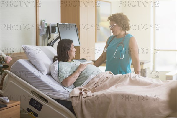 Doctor talking to pregnant patient in hospital room