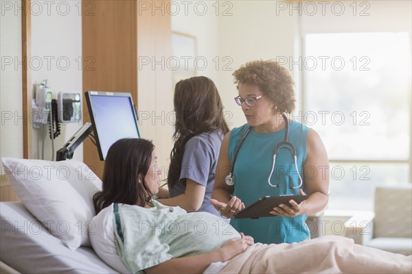 Doctor talking to pregnant patient in hospital room