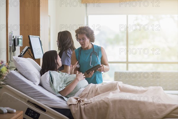 Doctor talking to pregnant patient in hospital room