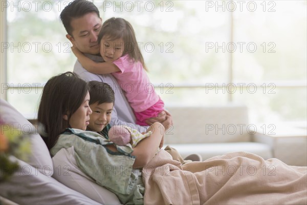 Family admiring newborn baby in hospital room