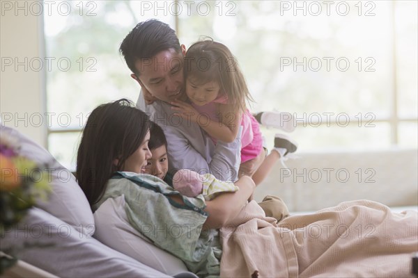 Family admiring newborn baby in hospital room