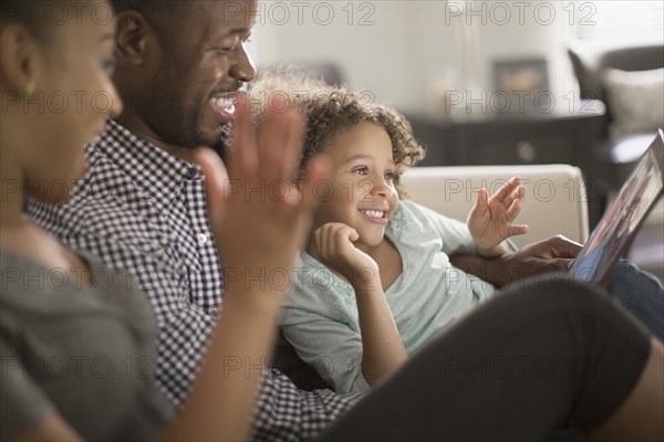 Family using digital tablet on sofa