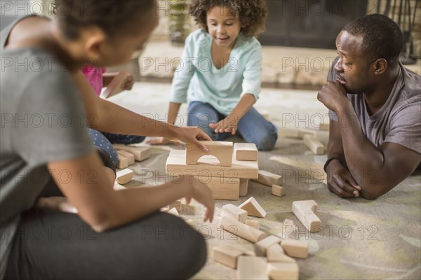 Family playing with building blocks in living room