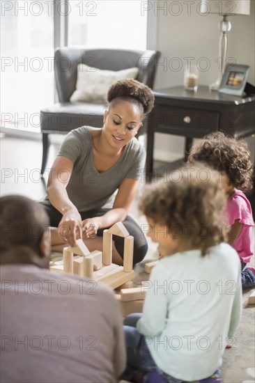 Family playing with building blocks in living room