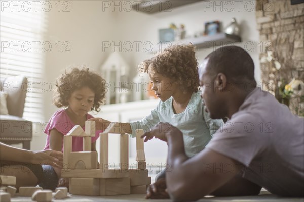 Family playing with building blocks in living room