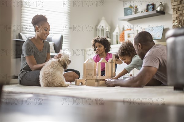 Family playing with building blocks in living room