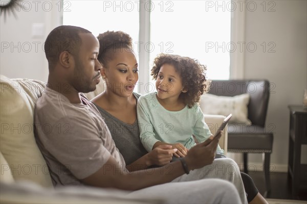 Family using digital tablet on sofa