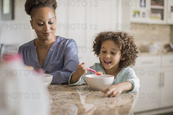 Mother and daughter eating at table