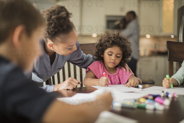 Mother and children drawing in kitchen