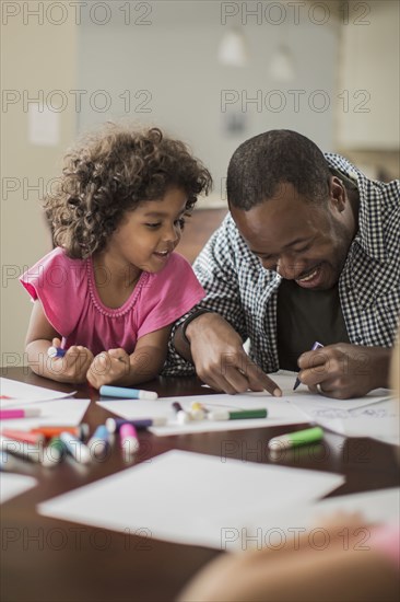 Father and daughter drawing in kitchen