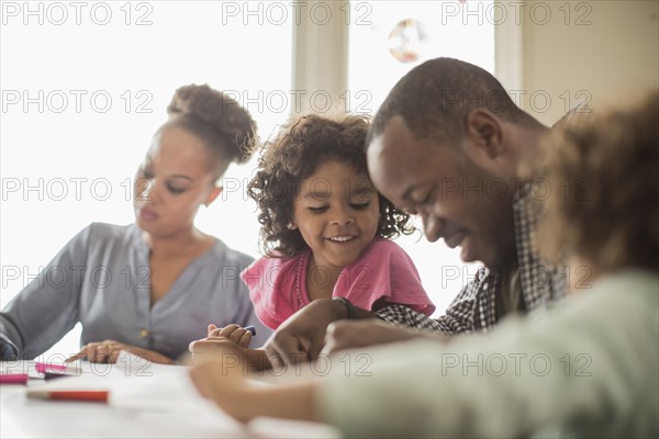 Family drawing together in kitchen