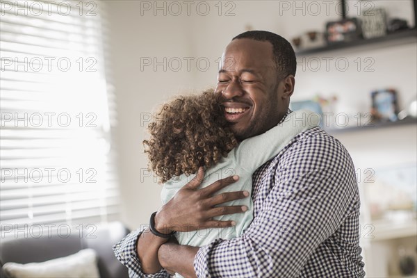 Father and daughter hugging in living room