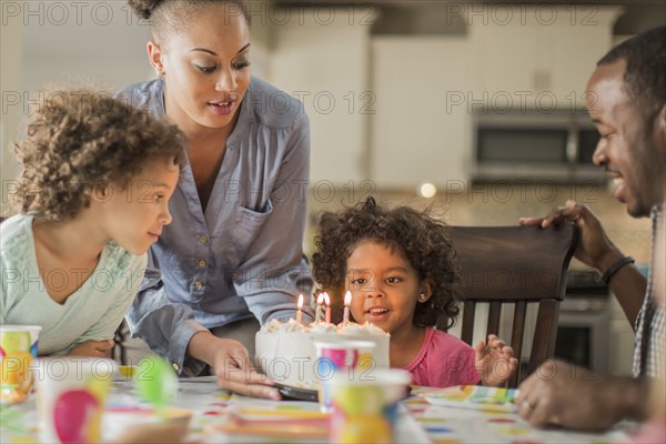 Girl admiring birthday cake at party