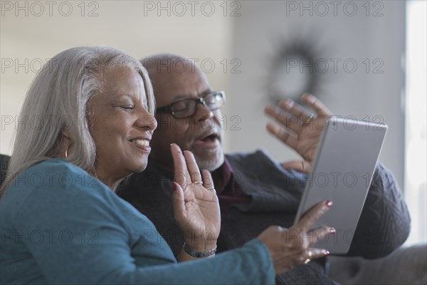 Older couple video chatting with digital tablet