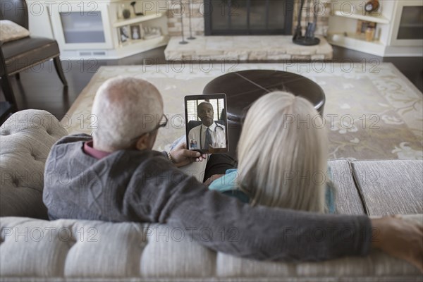 Older couple video chatting with digital tablet