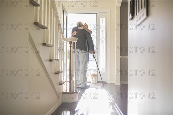 Man hugging visitor in front door