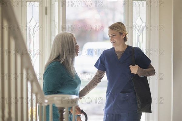 Nurse talking to patient in front door