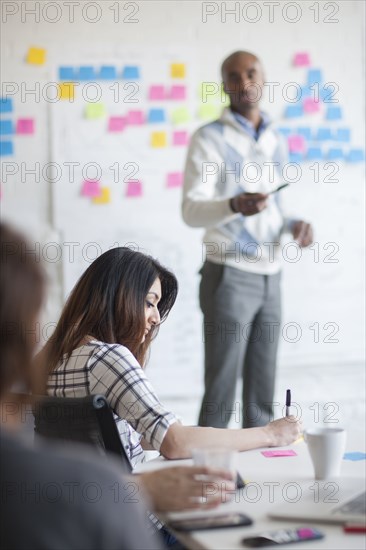 Business people writing notes in office meeting