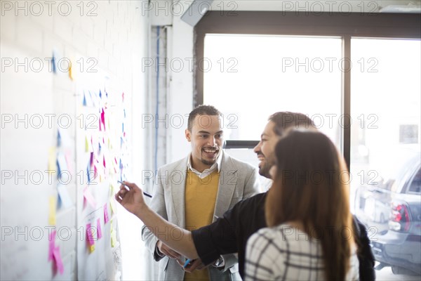 Business people using adhesive notes in office