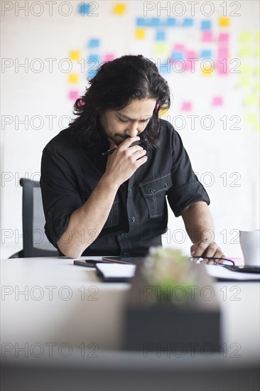 Mixed race businessman using digital tablet in office