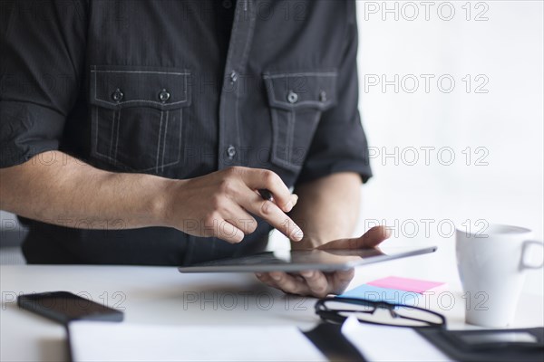 Mixed race businessman using digital tablet in office