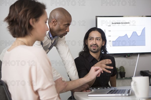 Business people using laptop in meeting