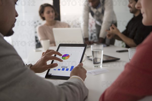 Business people using digital tablet in meeting