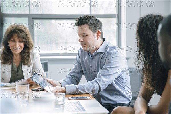 Business people using digital tablet in meeting