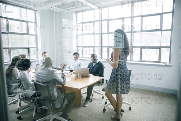 Businesswoman talking behind window in meeting