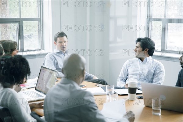 Business people talking behind window in meeting