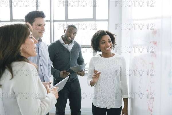 Business people reading whiteboard in meeting