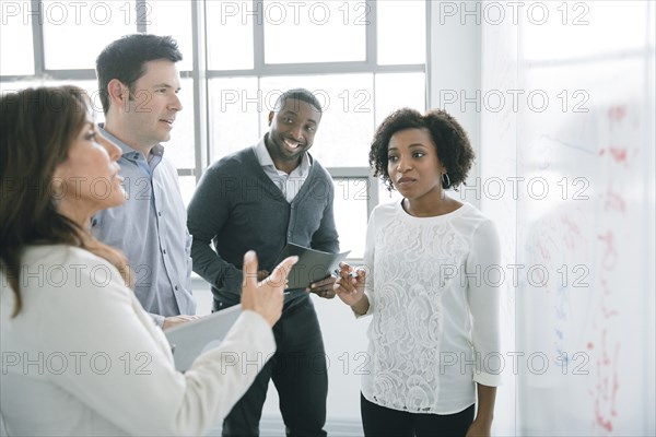 Business people talking near whiteboard in meeting