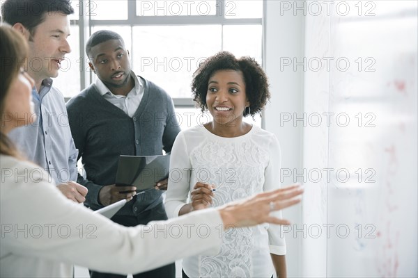 Business people talking near whiteboard in meeting