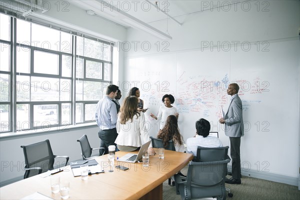 Businesswoman talking near whiteboard in meeting