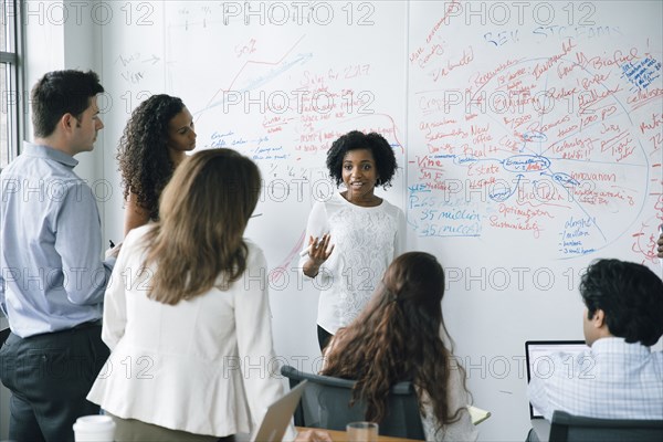 Businesswoman talking near whiteboard in meeting