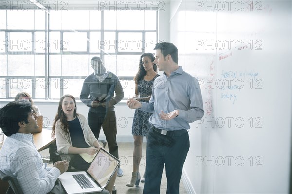 Businessman talking near whiteboard in meeting