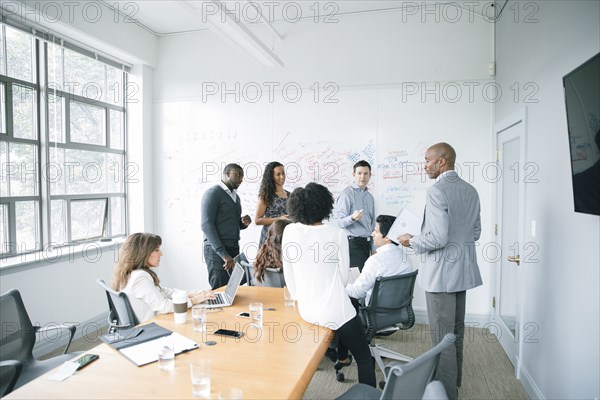 Businessman talking near whiteboard in meeting