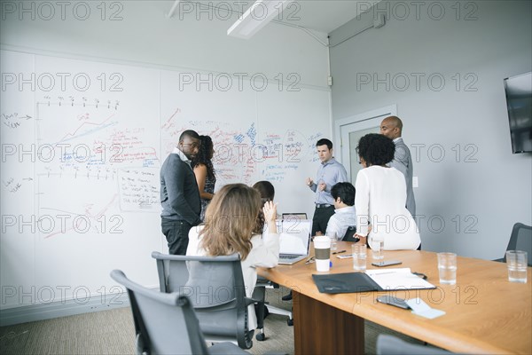 Businessman talking near whiteboard in meeting