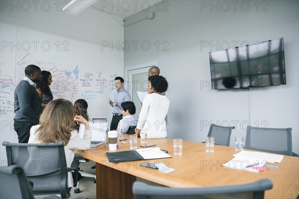 Businessman talking near whiteboard in meeting