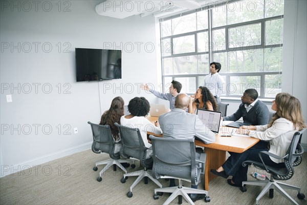 Businessman talking near visual screen in meeting