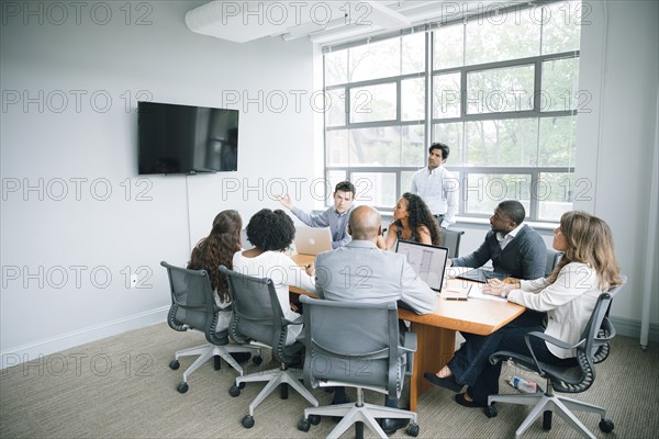 Businessman talking near visual screen in meeting