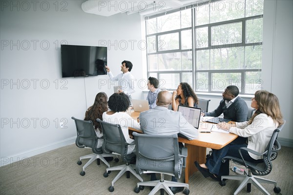 Businessman talking near visual screen in meeting