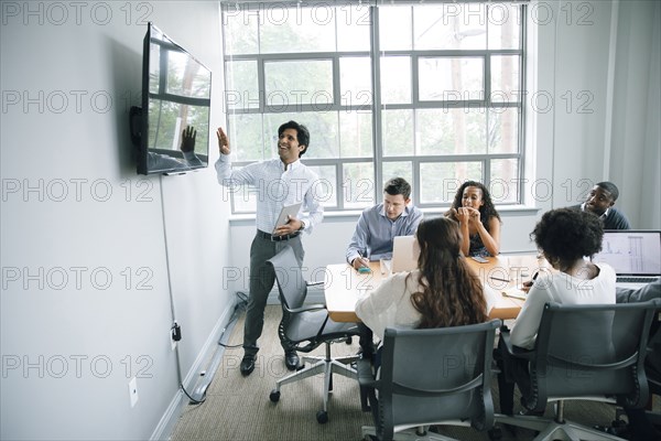 Businessman talking near visual screen in meeting