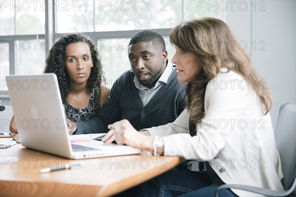 Business people using laptop in meeting