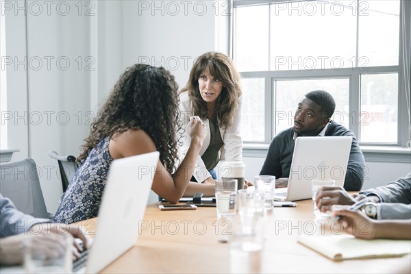 Business people using laptop in meeting