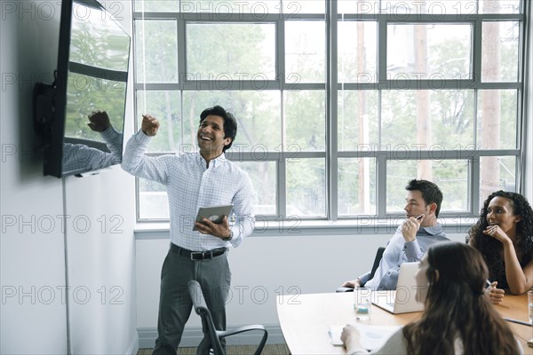 Businessman talking near visual screen in meeting